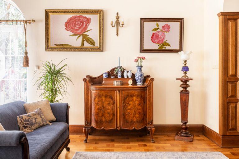 Antique sideboard in living room with pictures above